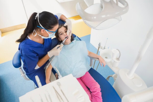 Dentist examining her young patient
